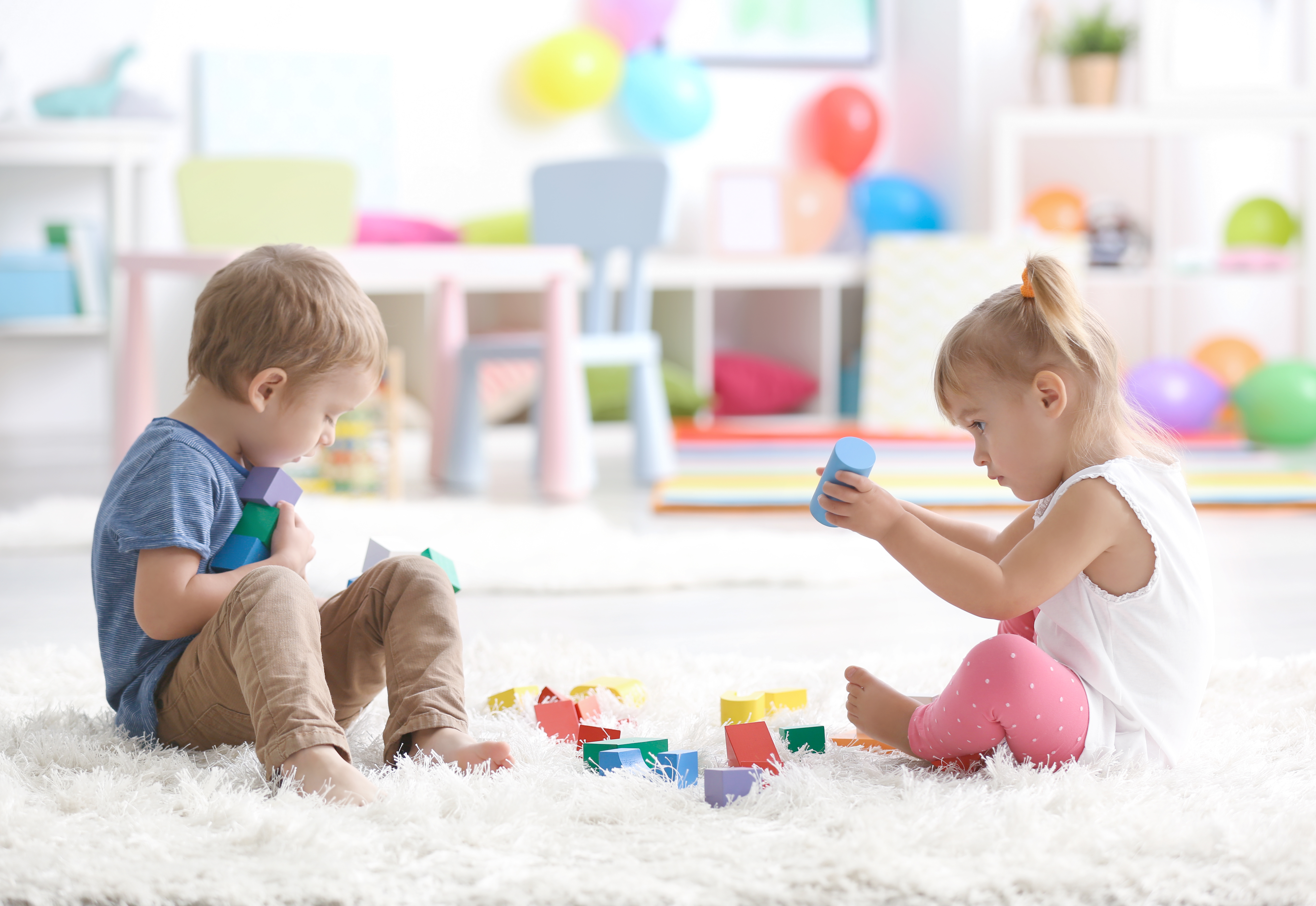 Two small children playing on floor